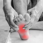 black and white image of foot with red spots on the bottom