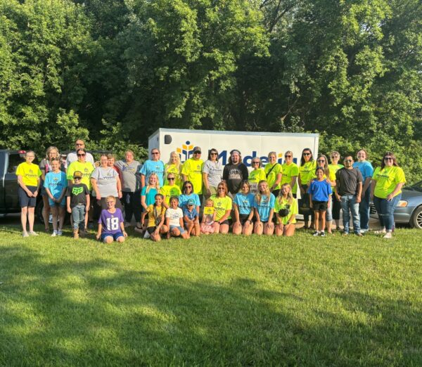 Staff in Madelia Health t-shirts standing in front of a trailer.