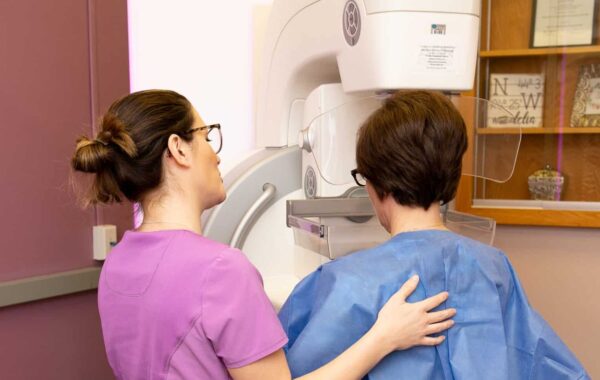 Mammograpy Madelia Health caregiver and patient in front of mammography machine.